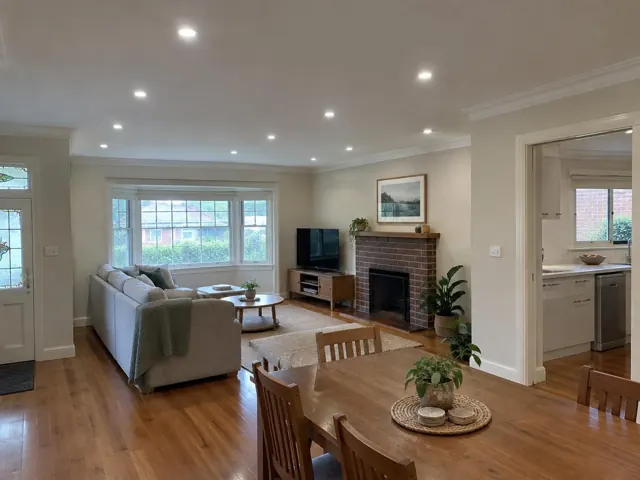 Living room with recessed ceiling downlights, timber floors and fireplace in Mayfield